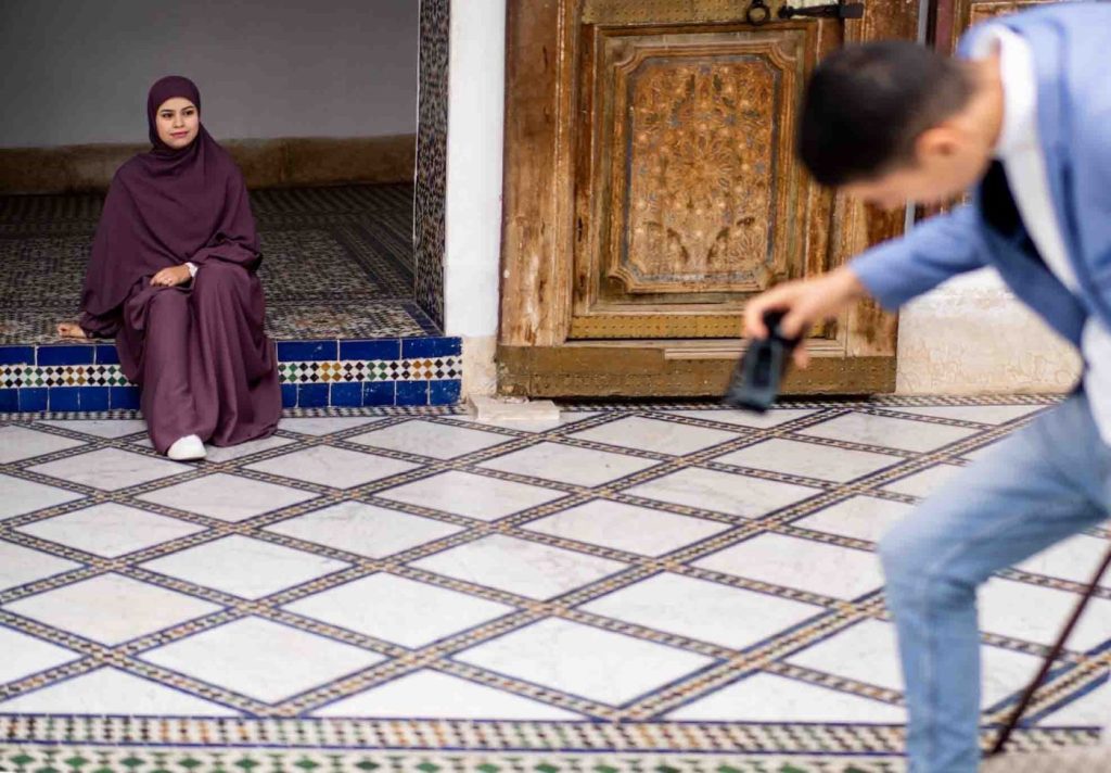 A Palace in Marrakesh, a man of a young couple taking some picture of his love.